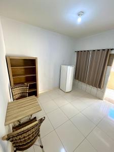 a kitchen with a table and a refrigerator at Kitnet Realeza in Várzea Grande