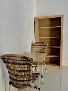 a table and two rattan chairs in a room at Kitnet Realeza in Várzea Grande