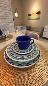 uma mesa com um copo azul e pratos sobre ela em Jardim das Palmeiras II Home Resort em Ubatuba