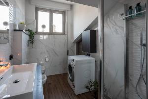 a bathroom with a washing machine and a shower at [Aeroporto Orio Al Serio • 10 Minuti] Attico Lusso in Seriate