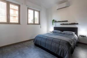 a bedroom with a large bed and two windows at [Aeroporto Orio Al Serio • 10 Minuti] Attico Lusso in Seriate