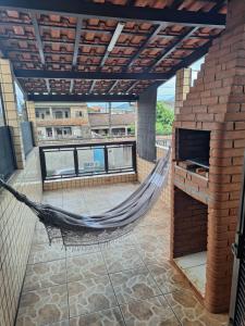 a hammock on the roof of a building with a patio at Recanto do Sossego in Guarujá