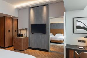 a hotel room with a sliding door with a tv at Sheraton Mall of the Emirates Hotel, Dubai in Dubai