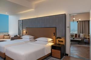 a hotel room with two beds and a living room at Sheraton Mall of the Emirates Hotel, Dubai in Dubai