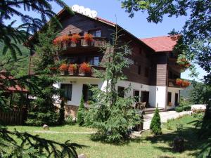 Una casa con flores en el balcón. en Complex Turistic Perla Trascaului, en Rimetea