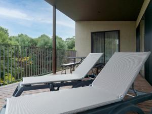 two lounge chairs and a table on a balcony at Rakuten STAY VILLA Kamogawa in Kamogawa