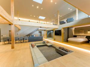 a large living room with a staircase and a couch at Rakuten STAY VILLA Kamogawa in Kamogawa