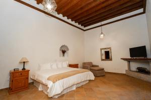 ein Schlafzimmer mit einem Bett und einem TV in der Unterkunft Casalinda San Miguel in San Miguel de Allende