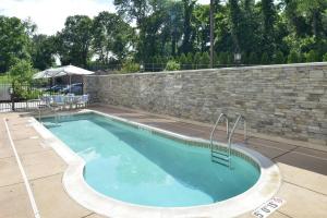 une piscine avec un mur de briques et un aphalt dans l'établissement SpringHill Suites by Marriott Philadelphia Valley Forge/King of Prussia, à King of Prussia