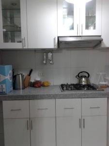 a kitchen with white cabinets and a stove top oven at Tait's House - Cómodo departamento Dúplex - Ate in Lima