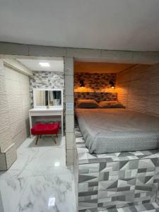 um quarto com uma cama grande e uma cadeira vermelha em Recanto Luxo Vista Mar em Angra dos Reis