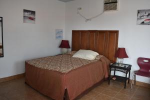 um quarto com uma cama e uma cadeira vermelha em Vistas de Loreto em Loreto