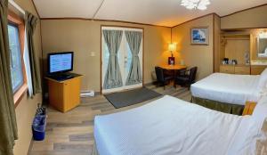 a hotel room with two beds and a television at Sunwapta Falls Rocky Mountain Lodge in Jasper
