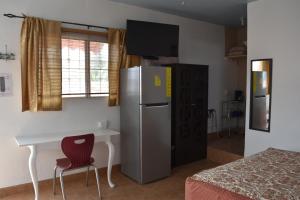 Cette chambre comprend un réfrigérateur, une table et un lit. dans l'établissement Vistas de Loreto, à Loreto