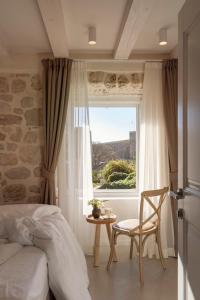 una camera con un letto e una sedia e una finestra di Villa Miri, Heritage Superior Villa with Swimming Pool a Dubrovnik