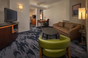 a living room with a couch and a television at Fairfield Inn and Suites by Marriott Harrisonburg in Harrisonburg