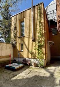 una casa con una ventana y hiedra creciendo en ella en Charmantes TinyHouse im Zentrum - MalliBase Apartments, en Hannover
