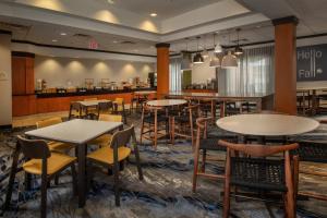 a restaurant with tables and chairs and a counter at Fairfield Inn and Suites by Marriott Harrisonburg in Harrisonburg
