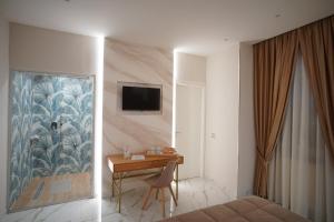 a bedroom with a desk and a tv on a wall at REDAMARE SUITE in Lago Patria