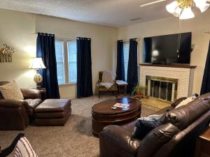 sala de estar con muebles de cuero y chimenea en V's Iris Haven, en Abilene