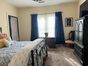 a bedroom with a bed and a dresser and a window at V's Iris Haven in Abilene