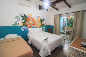 a bedroom with a bed with a flower mural on the wall at HOTEL CAREY in Pedasí Town