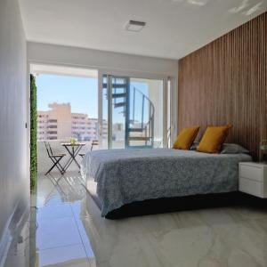 ein Schlafzimmer mit einem Bett und einem Balkon in der Unterkunft BlumLuxury Apartment in San Bartolomé de Tirajana