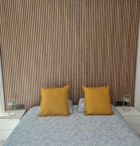 ein Schlafzimmer mit einem Bett mit zwei gelben Kissen in der Unterkunft BlumLuxury Apartment in San Bartolomé de Tirajana