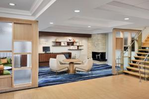 a lobby with a table and chairs and a fireplace at Fairfield Inn & Suites by Marriott Ottawa Kanata in Ottawa