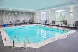 une grande piscine avec des chaises et des tables dans l'établissement Fairfield Inn & Suites by Marriott Ottawa Kanata, à Ottawa