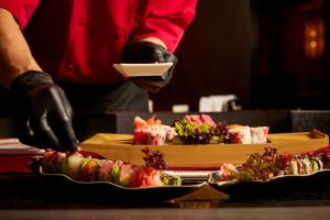 a person is holding a plate of sushi at Sheraton Bucharest Hotel in Bucharest
