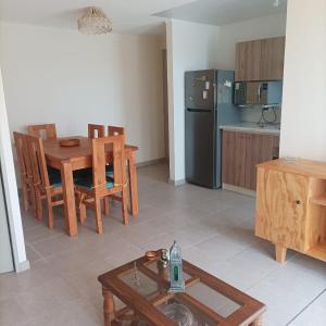 a kitchen and dining room with a table and a refrigerator at Amplio y comodo departamento in La Serena