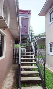 汕埠的住宿－Villa San Diego，通往带紫色门的房子的楼梯