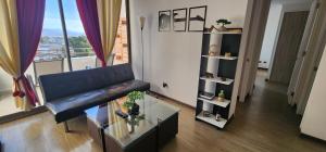 Una sala de estar con un sofá y una mesa de cristal. en Dpto 7 Calama, en Calama