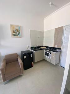 a small kitchen with a chair and a microwave at Vaz Lobo Kitnets in Mococa