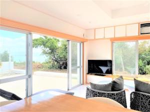 Ie的住宿－Ie shima-MONKEY - Vacation STAY 48431v，客厅配有桌椅和电视。