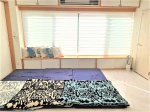 Ie的住宿－Ie shima-MONKEY - Vacation STAY 48431v，一张位于带大窗户的房间内的床铺