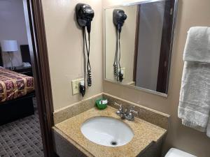 a bathroom with a sink and a mirror at Economy Inn & Suites in Ashtabula