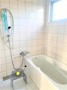Ie的住宿－Ie shima-MONKEY - Vacation STAY 48431v，白色的浴室设有浴缸和淋浴。