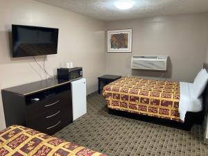 a hotel room with two beds and a flat screen tv at Economy Inn & Suites in Ashtabula