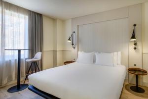 Un dormitorio con una gran cama blanca y una ventana en AC Hotel Los Vascos by Marriott, en Madrid