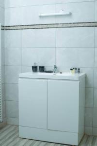 W białej łazience znajduje się umywalka i lustro. w obiekcie Crystal Apartments Area 43 w mieście Lilongwe