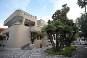 a building with palm trees in front of it at REDAMARE SUITE in Lago Patria