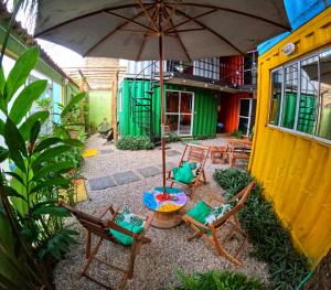 patio con sedie, tavolo e ombrellone di Container Hospedaria Paraty a Parati