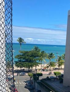 uma vista para uma praia com palmeiras e para o oceano em Quarto e Sala Beira Mar Maceió em Maceió