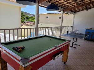 a pool table on a deck with a table at Casas Rio de Contas in Rio de Contas