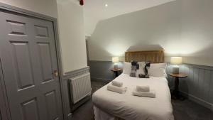 a bedroom with a bed with white sheets and pillows at The White Bull in Gisburn
