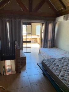 a bedroom with a bed and a view of a porch at Casa em Torres/RS in Torres