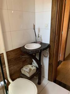 a bathroom with a sink and a toilet at Casa em Torres/RS in Torres