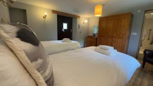 Habitación de hotel con 2 camas con sábanas blancas en The White Bull, en Gisburn
